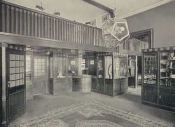 Verkaufsraum mit Galerie und Kassenpult im Obergeschoß, um 1930